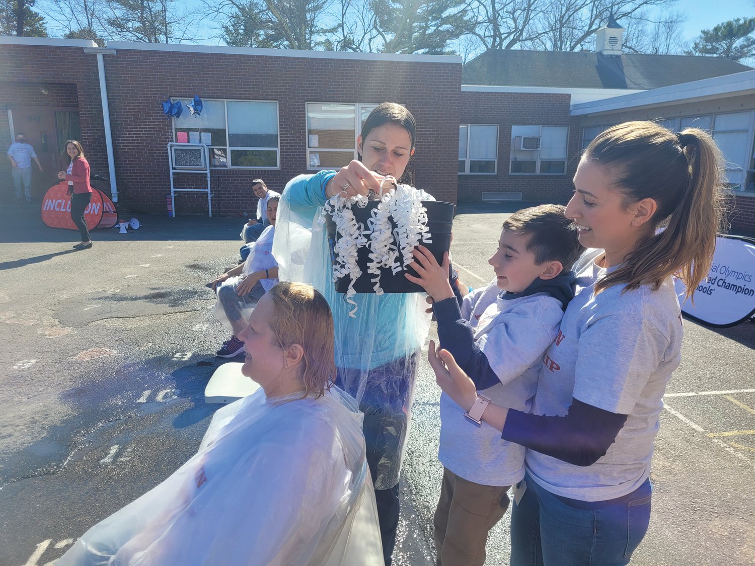 THE WINNER: Third-grader Elliot Sarli, with the assistance of PE/Health teacher Amanda Sloan and teacher Bryana Ruisi, pour water over Principal Helina Dlugon. Sarli raised more than $1,200 on his own; more than any other student.